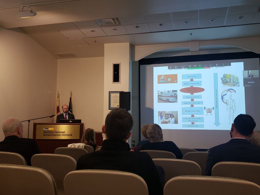 Sean Savitz giving a presentation at the podium.